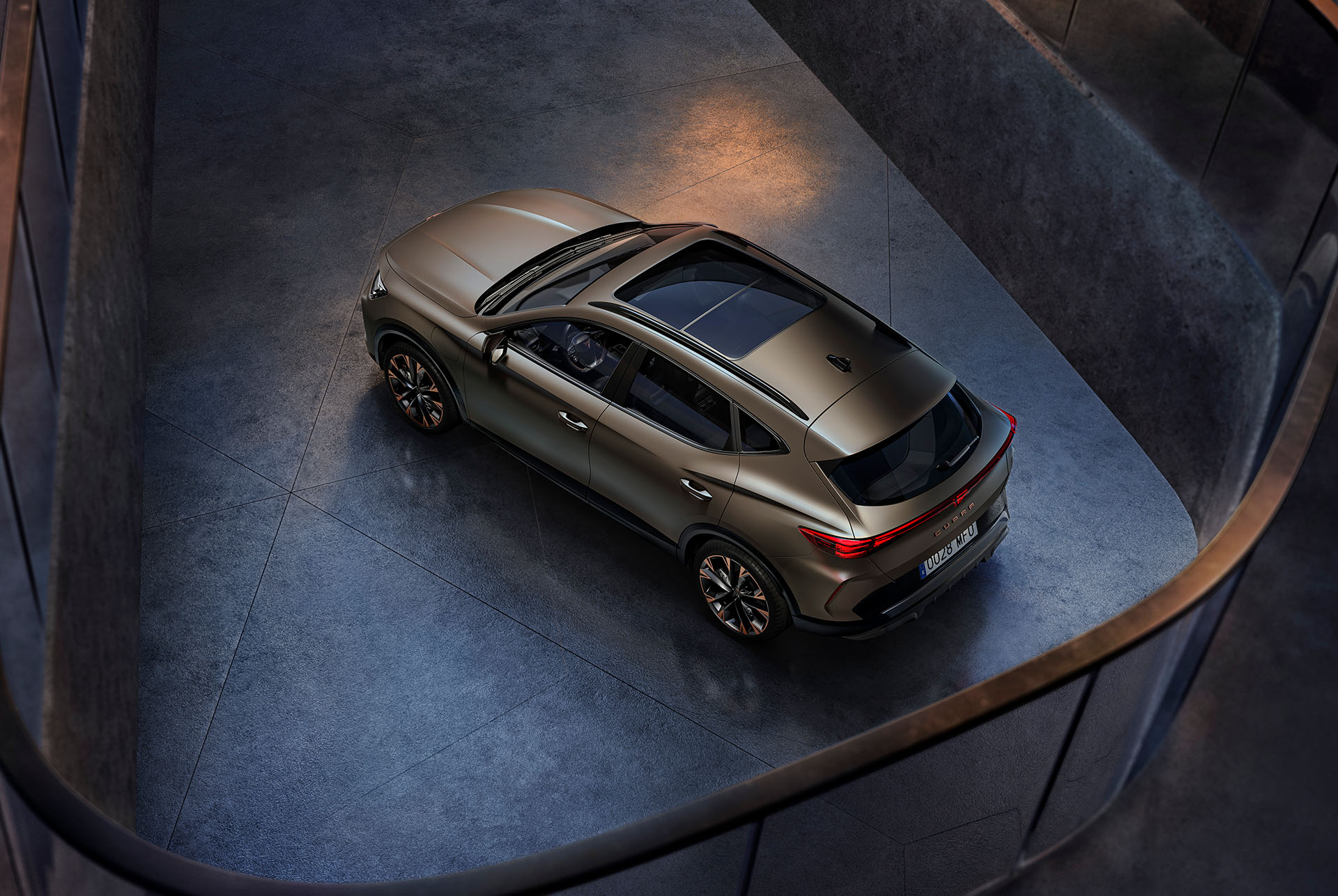 Vaade linnulennult CUPRA Formentorile kerevärviga Century Bronze Matt, mis on pargitud siledale tsementpinnale.