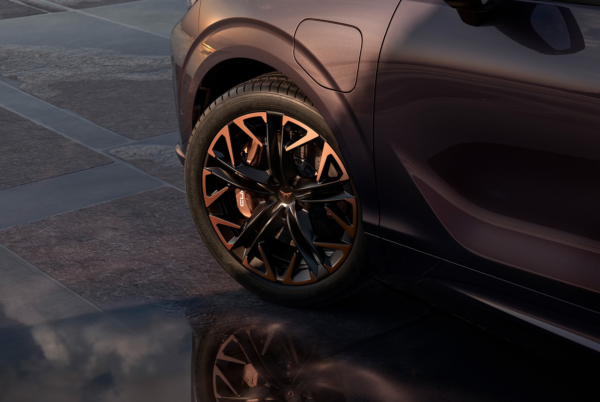 Uus CUPRA Terramar koos vasksete aktsentidega musta värvi 20-tolliste valuvelgedega Hadron Copper. Taustal on näha plaaditud teekate ning osa läikivast tumedast autokerest.
